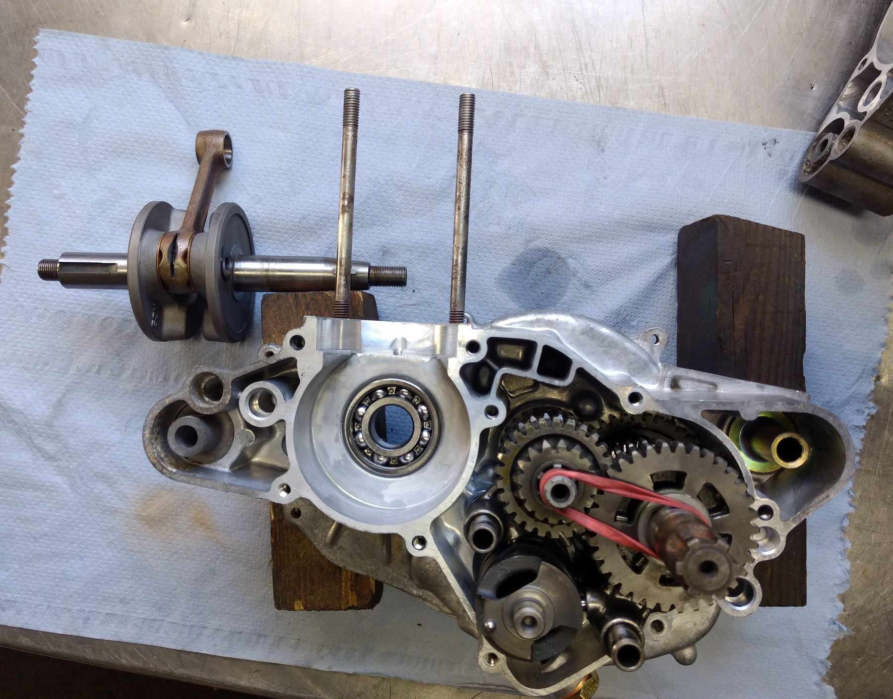 Zerlegter Motor einer Yamaha DT 80 LC auf der Werkbank: offenes Gehäuse, Getriebe, Kurbelwelle und Pleuel auf blauem Tuch