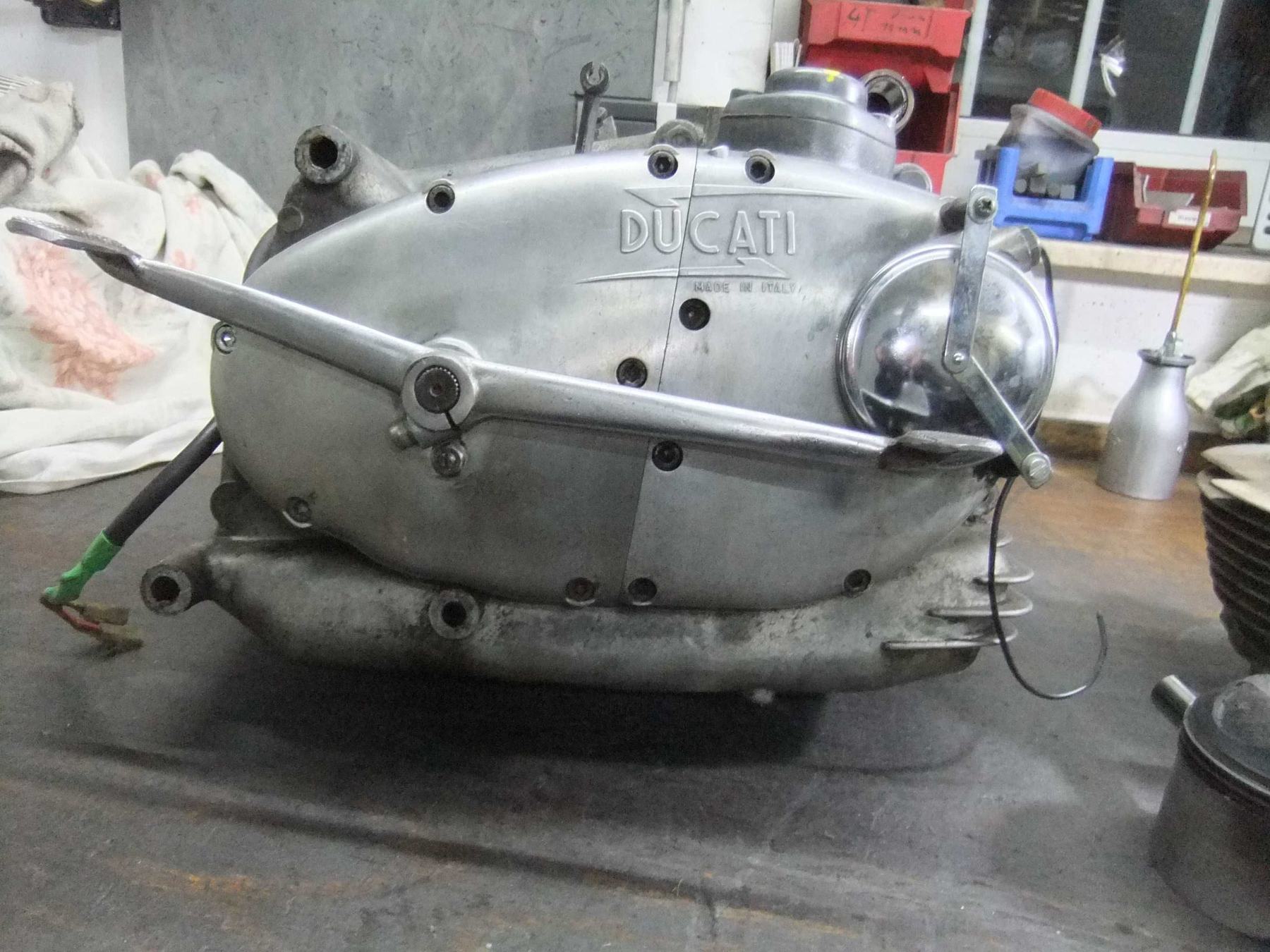 Historischer Ducati-Motorblock mit Prägung Made in Italy auf der gebrauchten Werkbank, Ölkännchen daneben